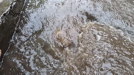 Auf-Einer-Seite-Der-Straße-Sammelt-Sich-Stark-Angesammeltes-Regenwasser-Auf-Den-Kanaldeckeln