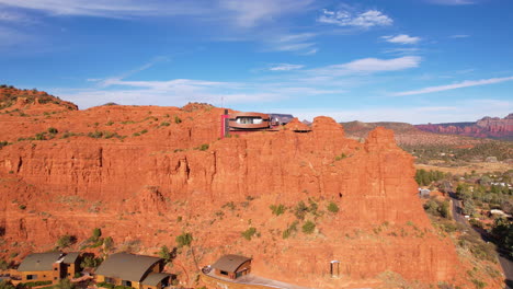 Vista-Aérea-De-Una-Casa-Futurista-En-La-Cima-De-Un-Acantilado-De-Arenisca-Roja-En-El-Paisaje-Desértico-De-Sedona,-Arizona,-EE.-UU.