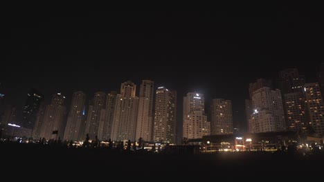 Toma-Panorámica-De-Edificios-Altos-Y-Rascacielos-Durante-La-Noche-En-La-Zona-De-Dubai-Marina-De-Los-Emiratos-Árabes-Unidos