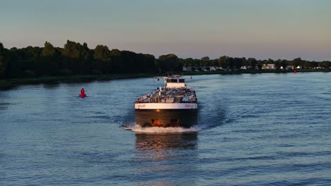 Ein-Flusskahn-Navigiert-An-Einem-Ruhigen-Abend-Durch-Einen-Ruhigen-Wasserweg