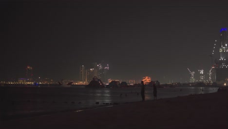 Schwenkaufnahme-Des-JBR-Strandes-Mit-Hochhäusern-Im-Hintergrund-Während-Der-Nacht-In-Den-Vereinigten-Arabischen-Emiraten