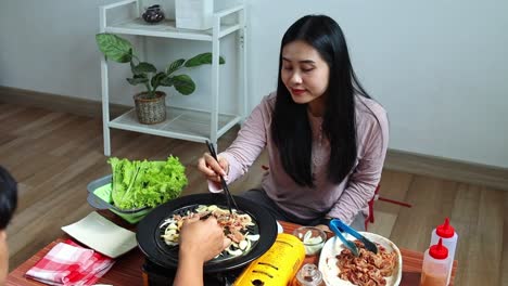 Asian-Couple-Grilling-Beef-Slice-Together-For-Making-Korean-Barbeque