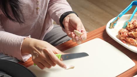 Woman-Peeling-Garlic-Preparation-For-Making-Korean-Barbeque-In-The-Kitchen