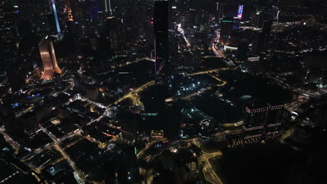 Aerial-view-tilting-toward-the-Merdeka-118-tower,-night-in-Kuala-Lumpur,-Malaysia