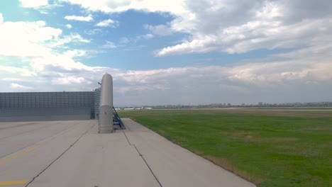 Airplane-taxiing-at-Sofia-airport-passes-by-a-jet-blast-deflector-and-ground-run-up-enclosure-at-Sofia-airport