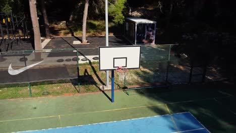 Outdoor-basketball-hoop-being-filmed-by-an-orbiting-drone