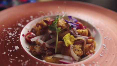 Beautiful-slow-motion-shot-of-a-finished-dish-of-“octopus-casserole”-lit-in-a-restaurant-kitchen