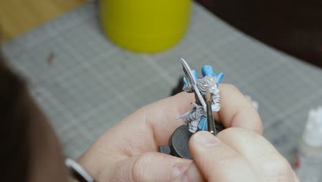 Vista-Aérea-Del-Artista-Pintando-Un-Modelo-De-Figura-De-Fantasía-En-Miniatura-En-Su-Estudio-Listo-Para-Jugar-Al-Juego-De-Rol-4k