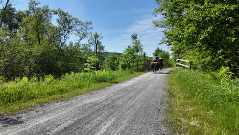 Cicloturistas-Viajando-Por-Un-Camino-De-Grava-En-Quebec,-Canadá