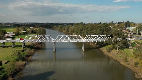 Toma-Aérea-De-Un-Dron-En-Morpeth,-Nueva-Gales-Del-Sur,-Sobrevolando-El-Río-Hunter-Hacia-El-Puente