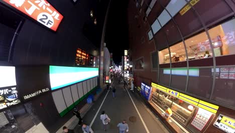 Wide-and-high-angle-footage-of-walking-down-the-famous-Kabukicho-Sakura-dori-Street,-Tokyo,-at-night-with-Japanese-locals-and-tourists-walking-around