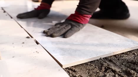 Toma-Real-De-Trabajadores-De-Decoración-Colocando-Baldosas-En-El-Piso,-Instalando-Una-Baldosa-Cerámica-Grande