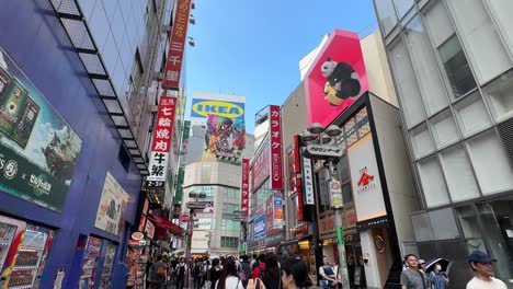 Animierte-3D-Panda-Plakatwand-Mit-Blick-Auf-Fußgänger,-Die-Durch-Das-Shibuya-Center-Gai,-Tokio,-Japan-Laufen