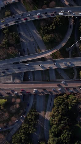 Vertikale-Luftaufnahme,-Starker-Verkehr-Auf-Dem-Amerikanischen-Highway-Kreuz-Und-Der-Kreuzung-Bei-Sonnenuntergang,-Drohnenaufnahme