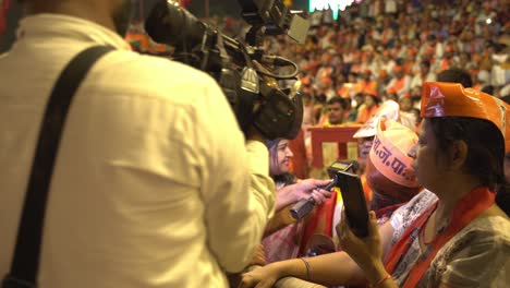 Indian-media-news-channel-field-reporter-and-journalists-taking-to-women-supporters-of-BJP-during-Lok-Sabha-election-campaign-public-rally-at-Assi-Ghat