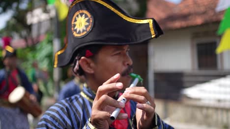 closeup,-a-Javanese-soldier-performing-a-ceremony-and-playing-a-flute-while-walking-in-place