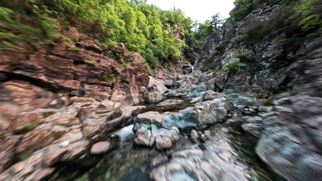 Cascata-del-serpente-waterfall-surrounded-by-lush-greenery-and-rocks,-aerial-view