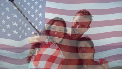 Familia-Tomándose-Un-Selfie-En-La-Playa-Con-Una-Bandera-Estadounidense-Ondeando