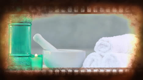 Spa-essentials-with-candle-and-towels-animation-over-filmstrip-border