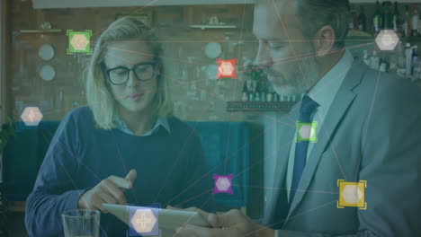 Business-data-network-animation-over-two-colleagues-discussing-work-on-tablet