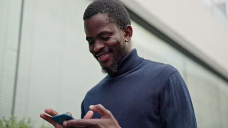 Black-man,-walking-in-city-with-smile-and-phone