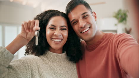 Selfie-of-happy-couple-in-living-room-with-keys-to