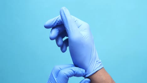 Doctor-hand-with-glove-on-wooden-background
