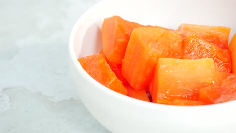 Slice-of-papaya-on-white-plate