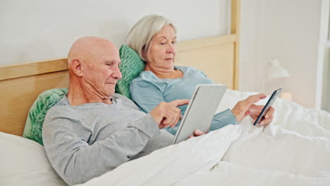 Älteres-Paar-Auf-Dem-Bett-Mit-Tablet
