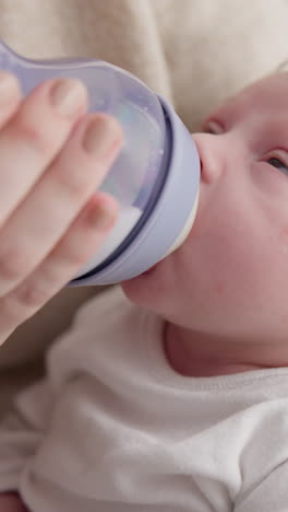 Baby,-sleeping-and-mother-with-bottle-for-feeding