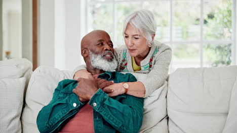 Senior-couple,-hug-and-talking-on-sofa-with-love