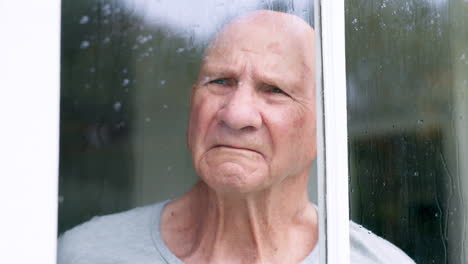 Sad,-window-and-senior-man-at-a-retirement