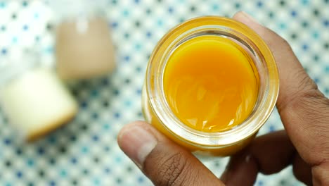 Holding-a-mango-pudding-in-a-glass-jar-,