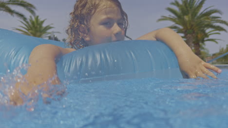 Niño-Con-Flotador-En-Piscina-Al-Aire-Libre