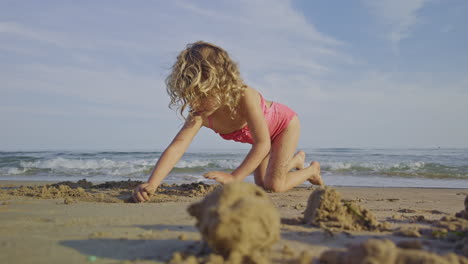 Pequeña-Niña-Jugando-Junto-Al-Mar-En-Una-Playa