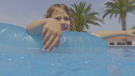 Niño-Con-Flotador-En-Piscina-Al-Aire-Libre