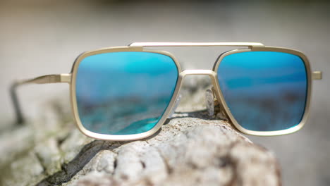 Mirrored-sunglasses-on-a-beach