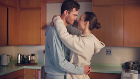 Couple,-hug-and-forehead-in-kitchen