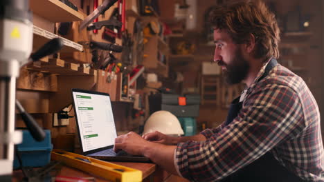 Man,-workshop-and-carpenter-with-a-laptop
