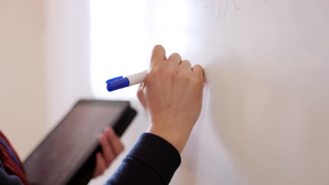 Whiteboard,-tablet-and-teacher-hands-writing