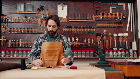 Leather-work,-man-in-workshop-with-tools