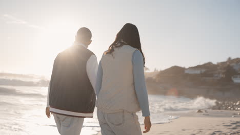 Holding-hands,-couple-and-walking-on-sunset-beach