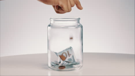 Glass,-jar-and-hand-with-money