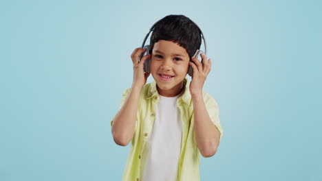Kid,-dancing-and-listening-to-music-in-studio
