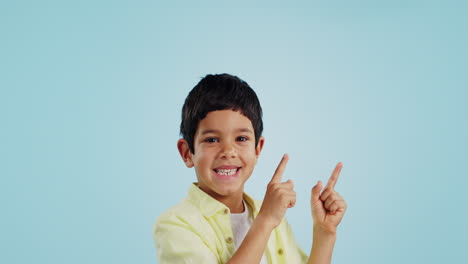 Kid,-boy-and-smile-while-pointing-in-studio