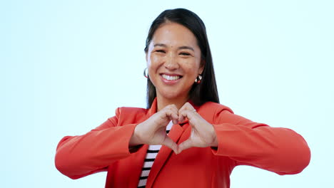 Asian-woman,-heart-sign-and-studio-for-smile