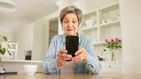 Phone,-smile-and-senior-woman-in-the-kitchen