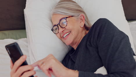 Cellphone,-laughing-and-senior-woman-in-bed