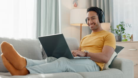 Man,-laptop-and-headphones-on-sofa-for-music