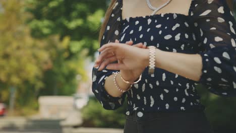 Beautiful-Blonde-Girl-In-Printed-Tops-Checking-Time-On-Her-Watch-While-Waiting-For-Her-Date-At-The-Park---Medium-Closeup-Shot-Slow-Motion